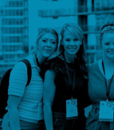 Four women from the Gibney Family Foundation smiling on a rooftop terrace with apartment buildings in the background