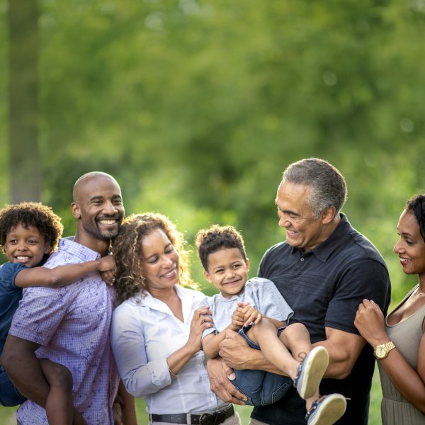 Multigenerational family with trees in background