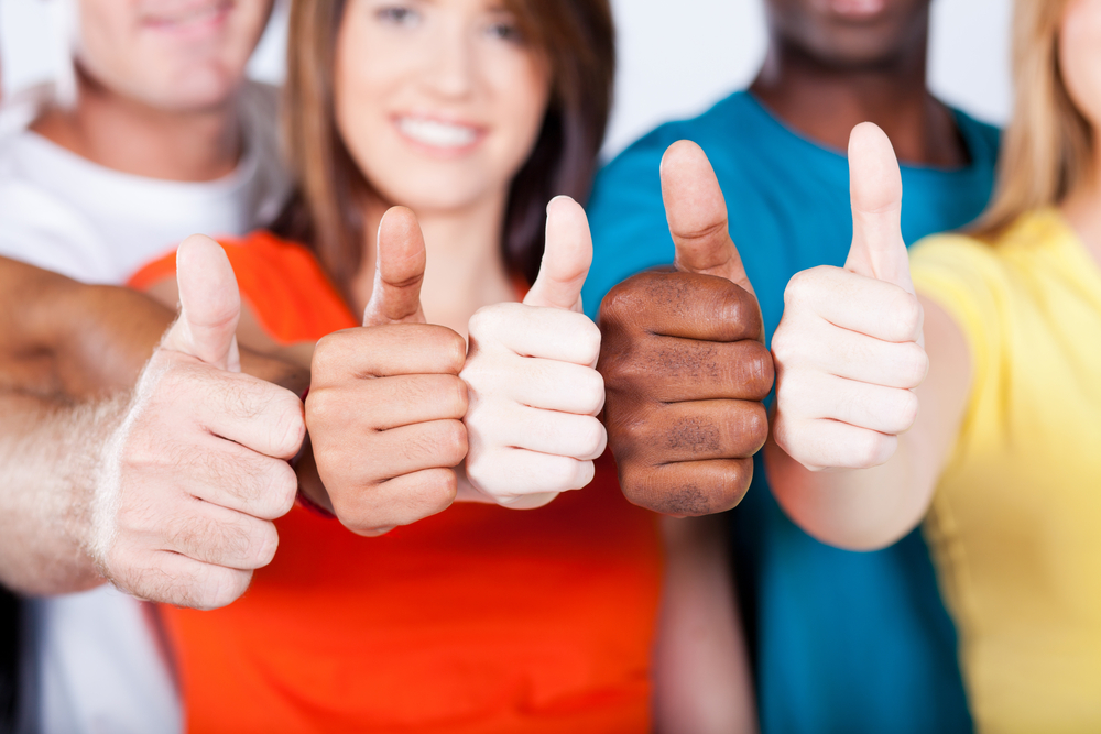 five people hold their thumbs up