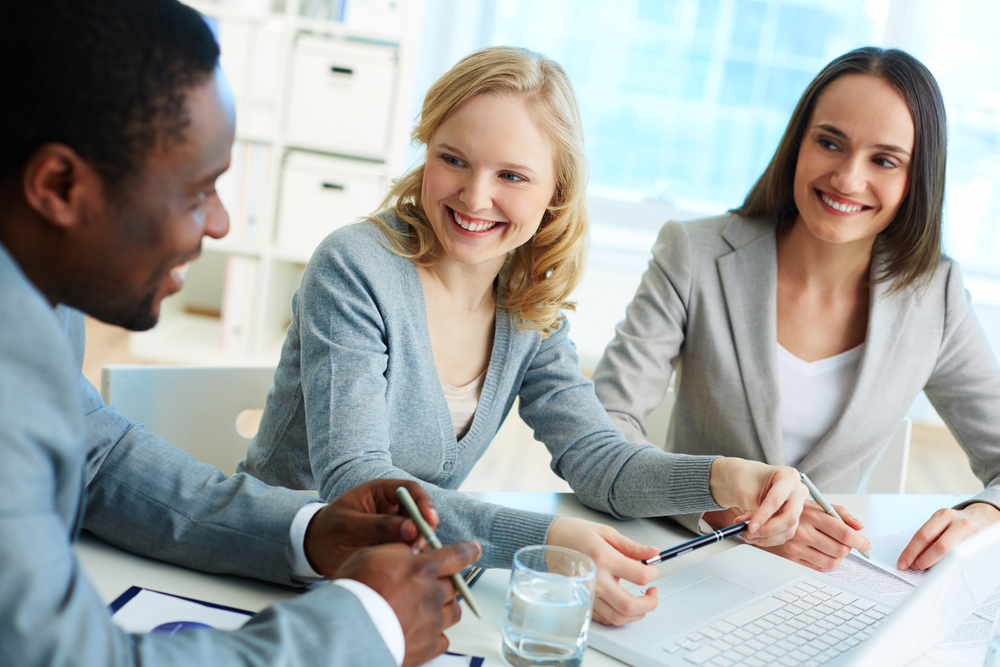 Two women and a man sit at a table, where two woman are clearly advising the man on a topic