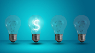 4 lightbulbs are standing against a blue background; one is lit up with a dollar sign in the middle