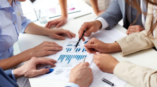 Board meeting where people are analyzing numbers on a sheet