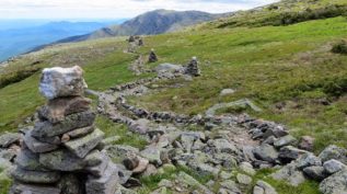 Rocky side of a mountain with green grass