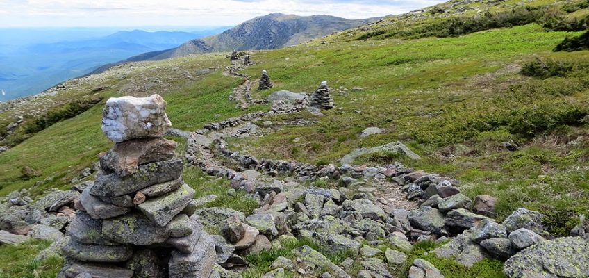 Rocky side of a mountain with green grass