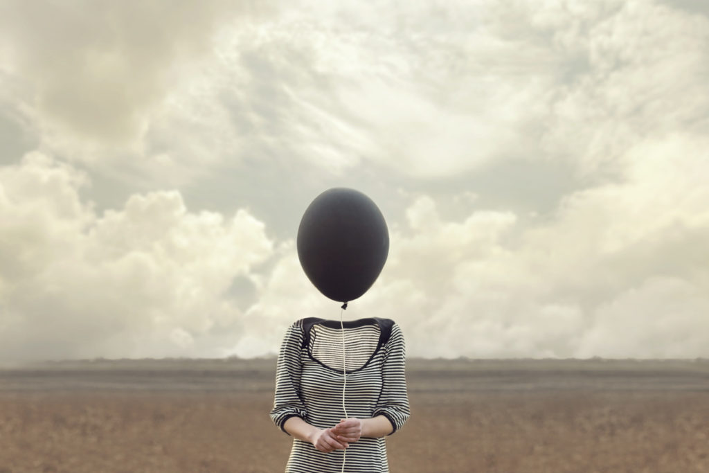 woman's head replaced by a black balloon
