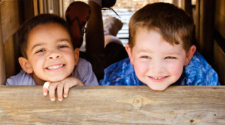 two young children smile at the camera