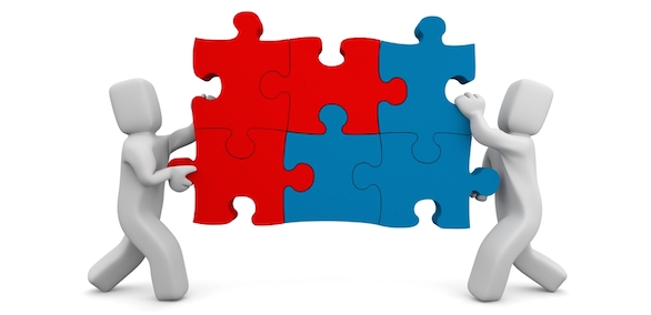 two people push a puzzle piece together