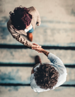 aerial shot of two people shaking hands in a professional work setting