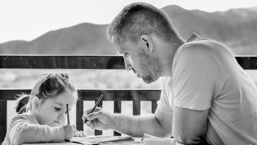 Young girl and father drawing outdoors