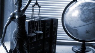 lady justice statue and globe on desk