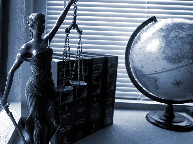 lady justice statue and globe on desk