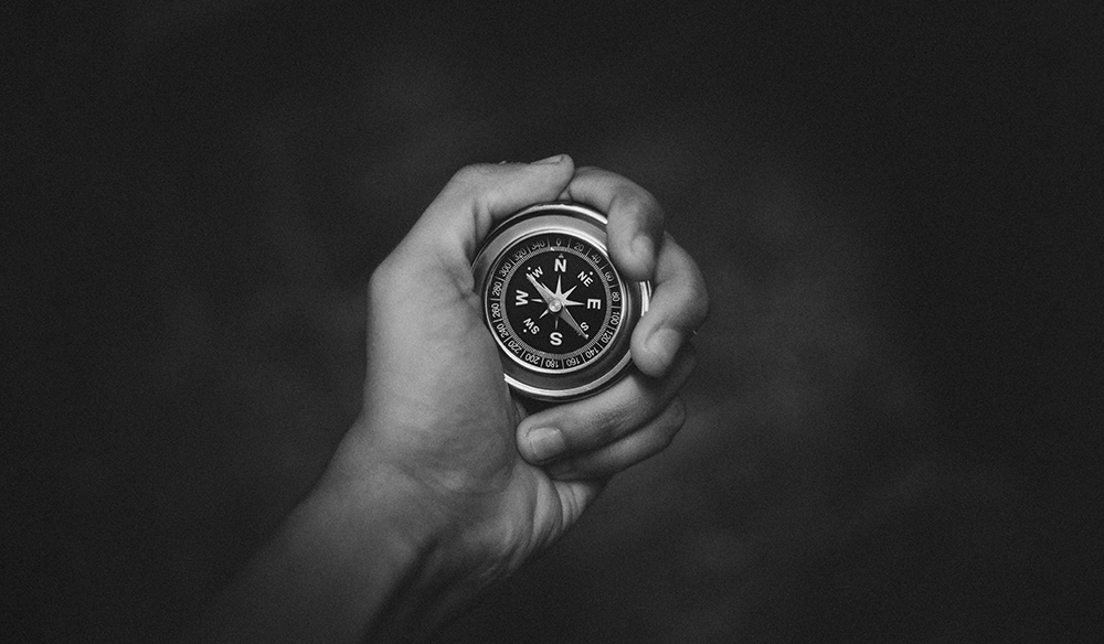 hand holding compass