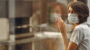 woman wearing mask looking at reflection
