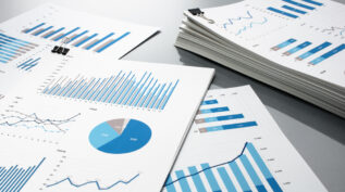 stacks of papers with blue and gray charts and graphs