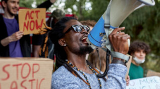 Young black man with megaphone at protest against climate change