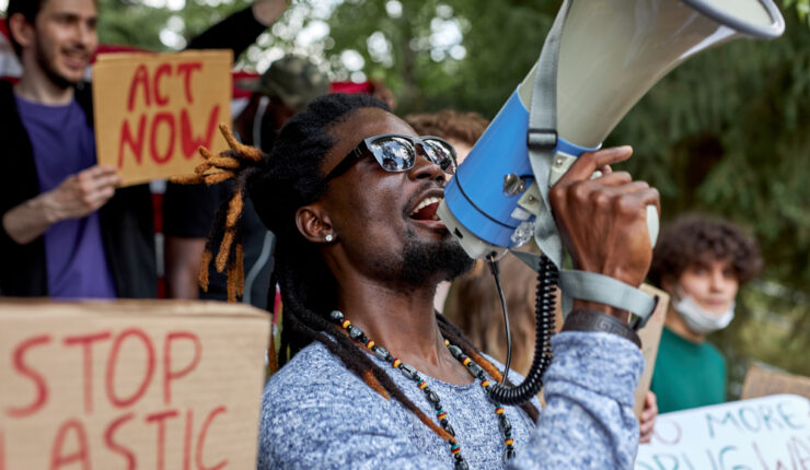 Young black man with megaphone at protest against climate change
