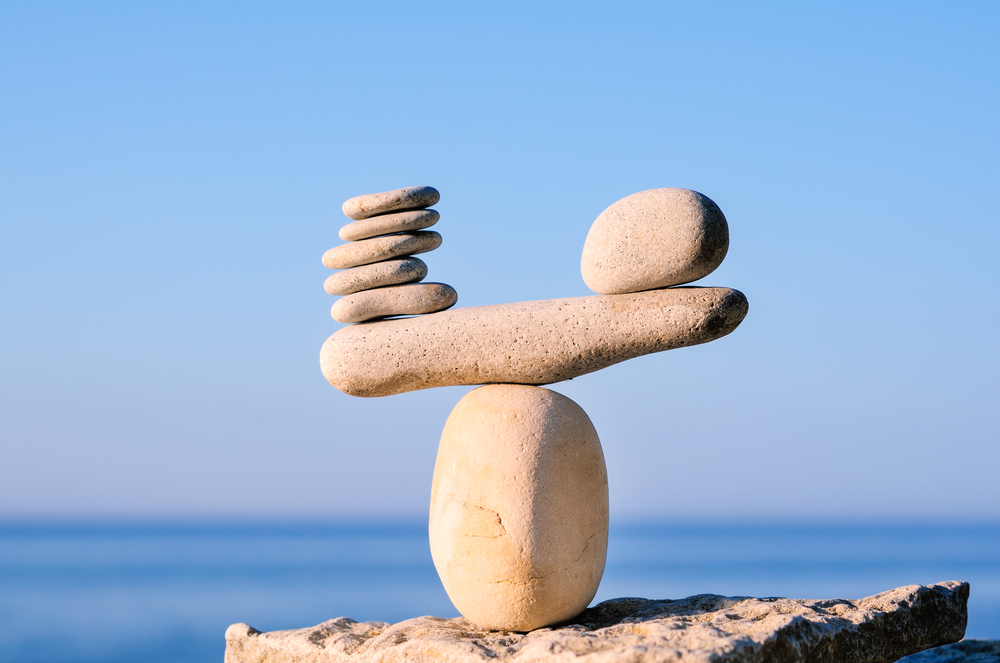 Multiple stones on left side balanced by single, larger stone on right side