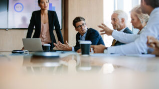 several people talking around boardroom table