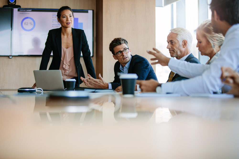 several people talking around boardroom table