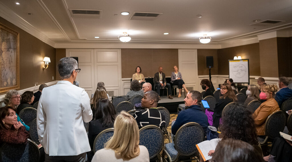 An attendee at the 2022 National Forum on Family Philanthropy asks a question on systems change