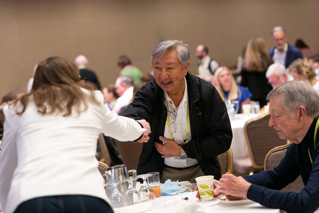 Two attendees shaking hands at the 2022 National Forum on Family Philanthropy