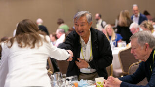 Two attendees shaking hands at the 2022 National Forum on Family Philanthropy