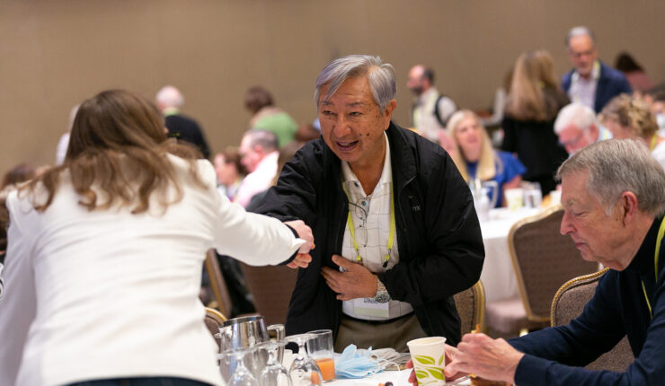 Two attendees shaking hands at the 2022 National Forum on Family Philanthropy
