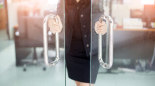 Woman in business attire opening a door