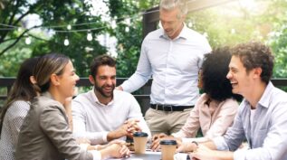 Colleagues collaborating and laughing around a table