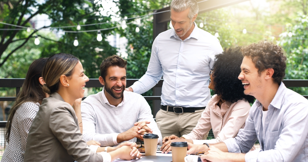 Colleagues collaborating and laughing around a table